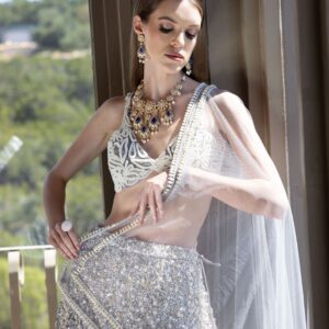 A woman in a silver Rushi posing on a balcony.