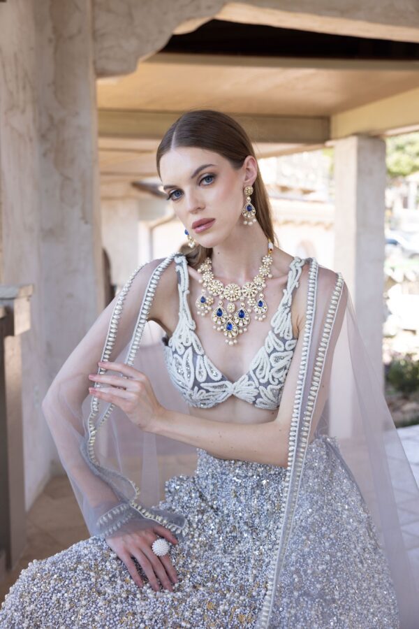 A woman in a white and silver Rushi posing for a photo.