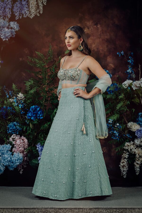 A model in a blue SIALA posing in front of flowers.