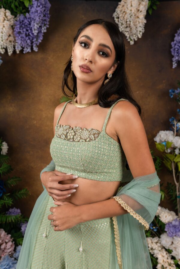 The model is wearing a green embroidered Toraya lehenga and dupatta.