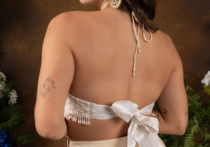The back view of a woman in Kiya- IVORY PANT LEHENGHA SET with a bow.